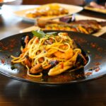 Healthy food concept. Spaghetti with shrimps, prawns and mussels. Blur plates with foods background.